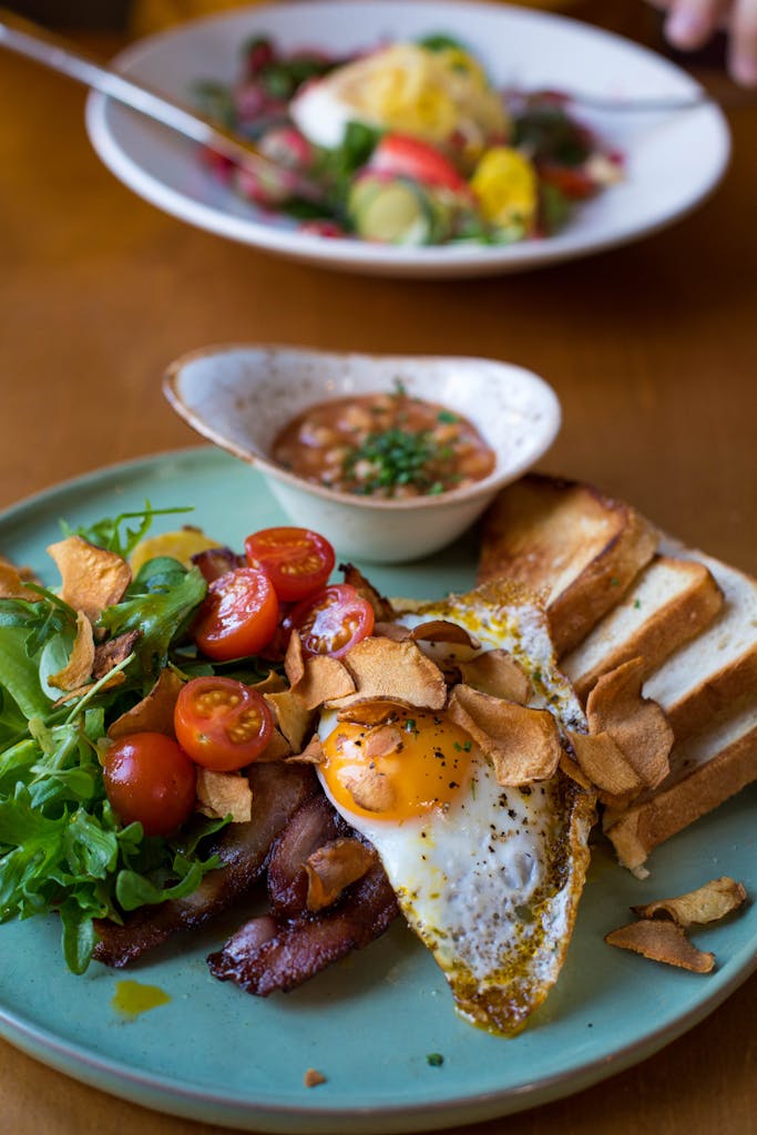 Fresh ingredients for anti-inflammatory breakfast recipes A vibrant breakfast plate featuring bacon, sunny side up egg, and fresh veggies.
